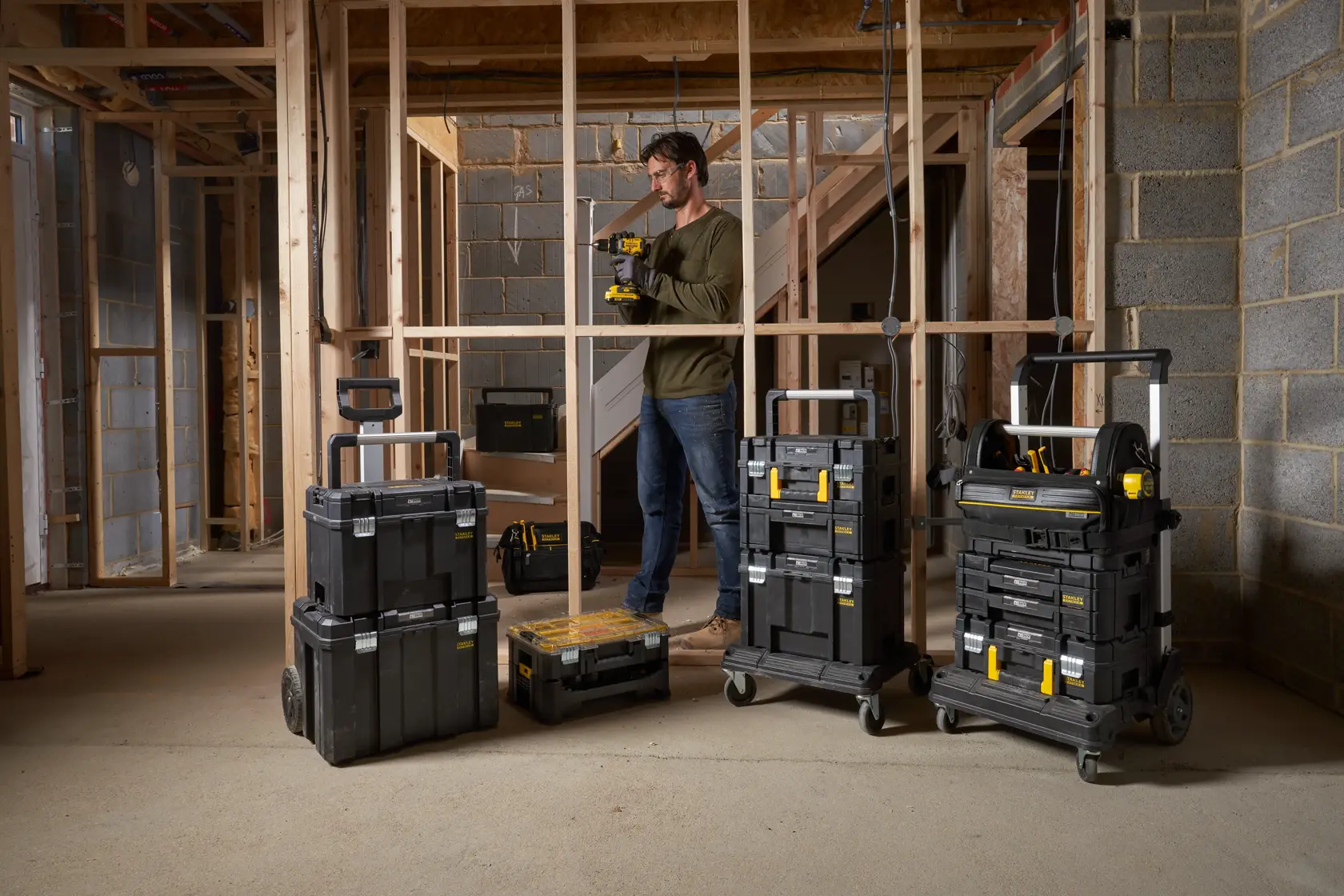 STANLEY FMST82967-9 rolling tool storage boxes in construction site, multiple stacked units with handles.