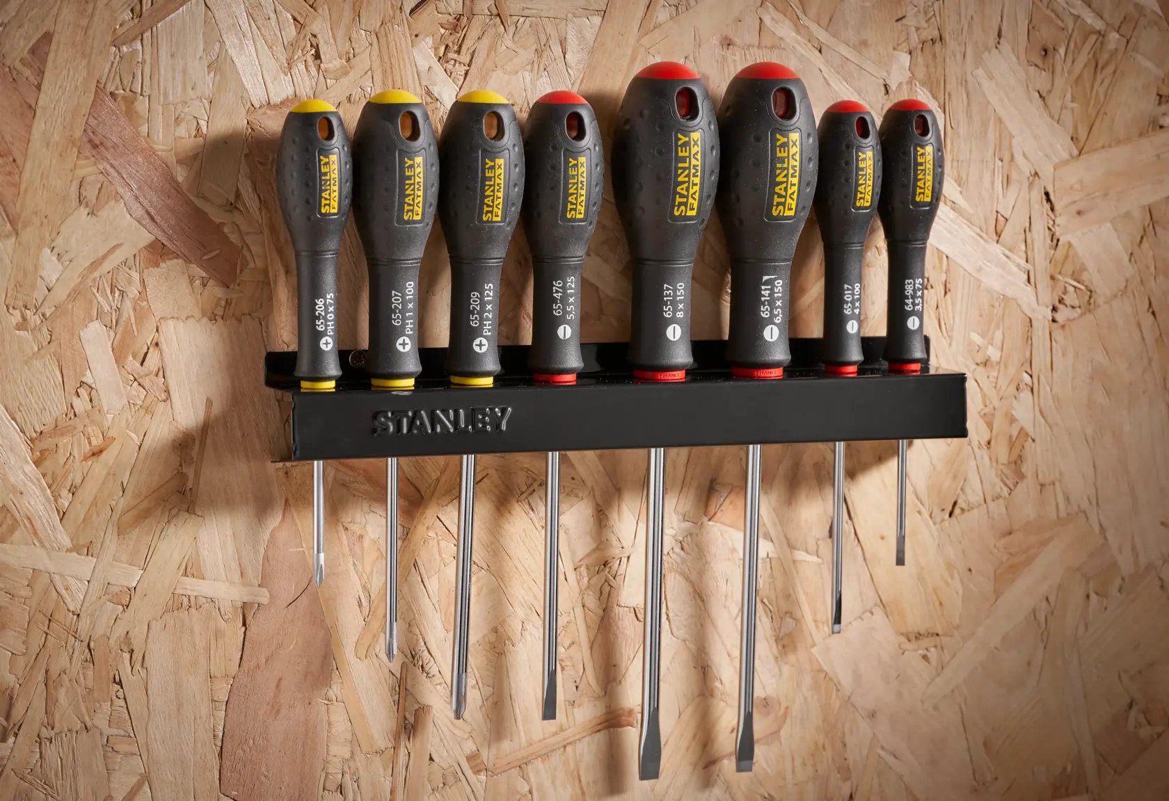 Photo of STANLEY 0-65-437 screwdriver set with black and yellow handles, stored on a wall-mounted rack.