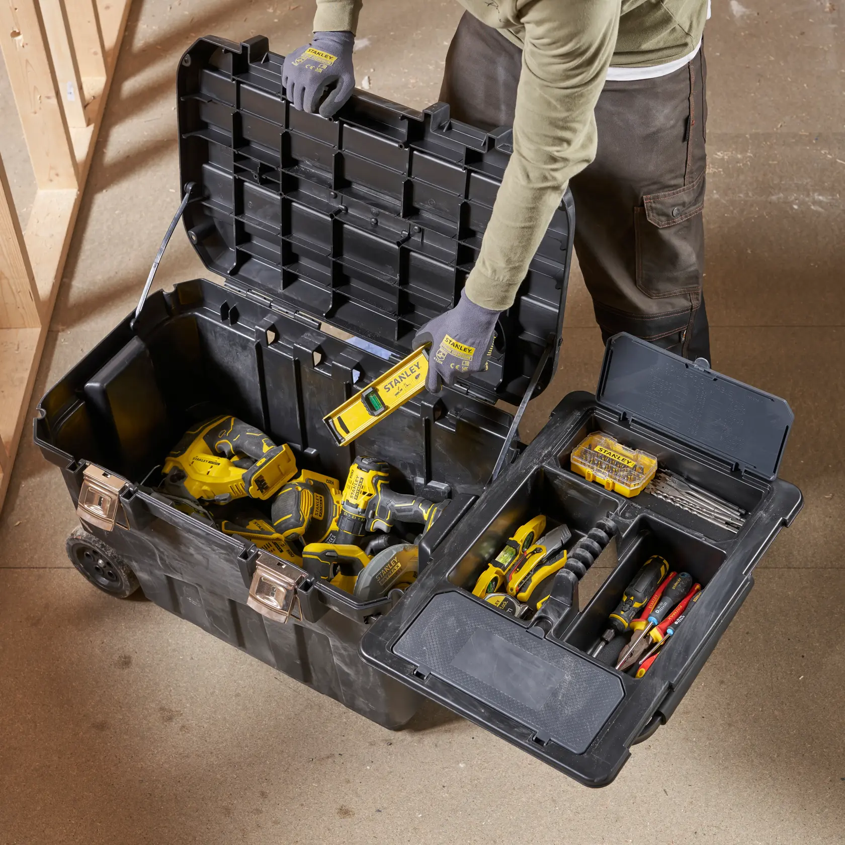 STANLEY 1-92-978 tool box open with hand tools and power tools, shown from above in workshop setting.