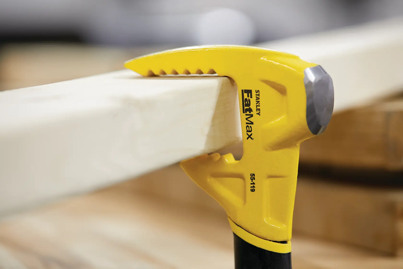Photo of STANLEY FatMax 55-119 claw bar gripping wooden plank, close-up view.