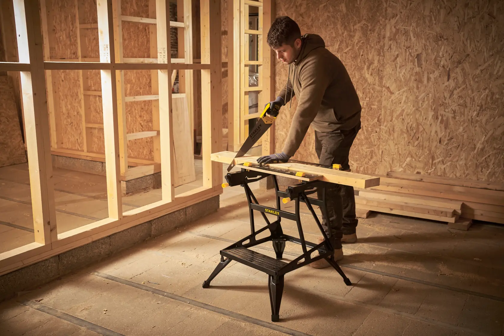 STANLEY STST83400-1 sawhorse in use, supporting wood plank in construction site.