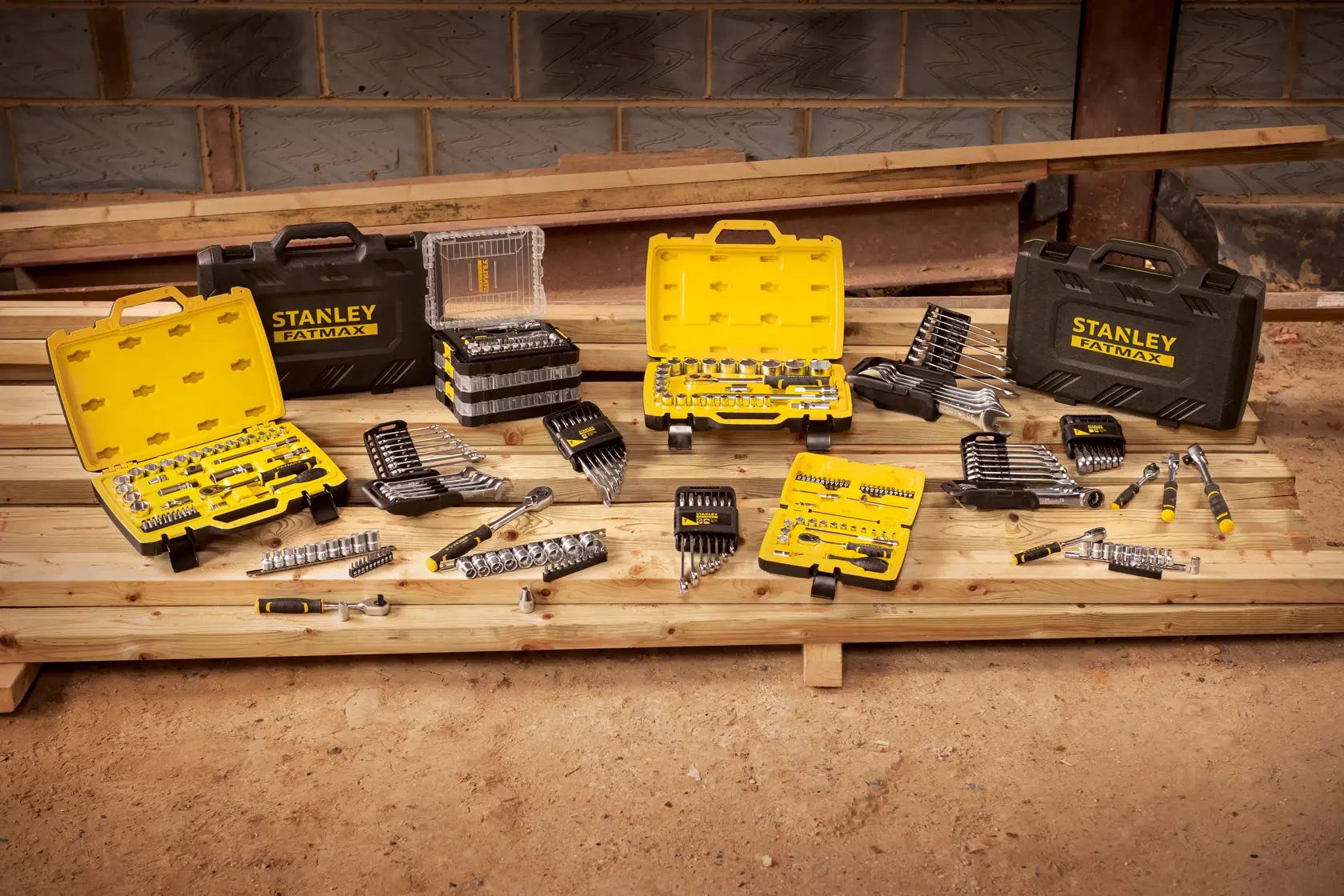STANLEY STMT82663-0 tool sets and cases displayed on wooden planks in a workshop setting.