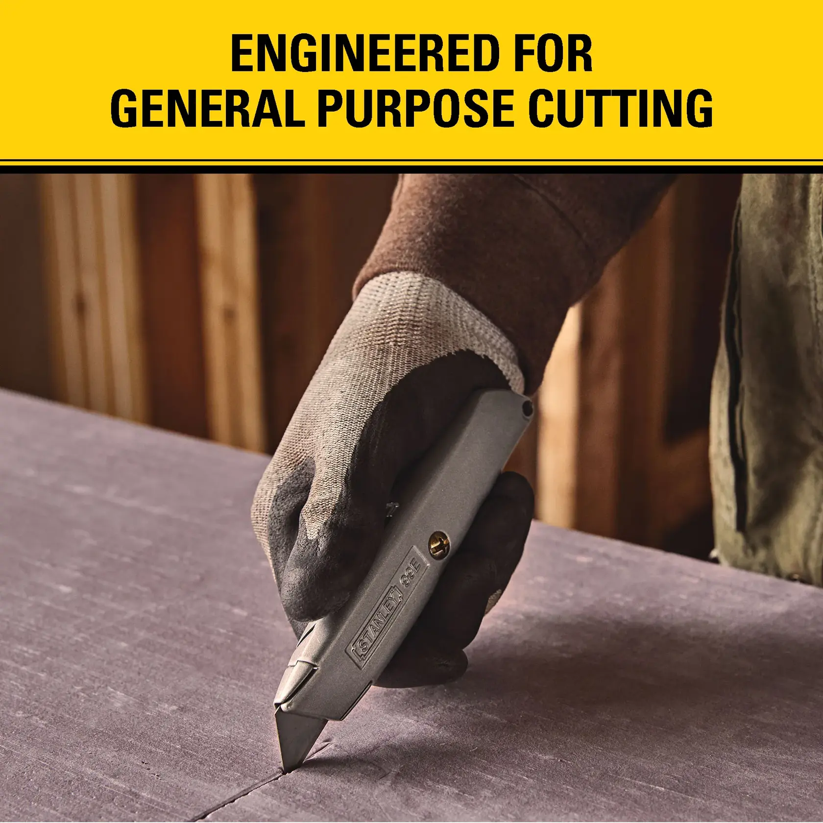 A gloved hand using a STANLEY utility knife, model 11-921L, to cut a sheet of material on a work surface. Text above reads 'Engineered for general purpose cutting.'