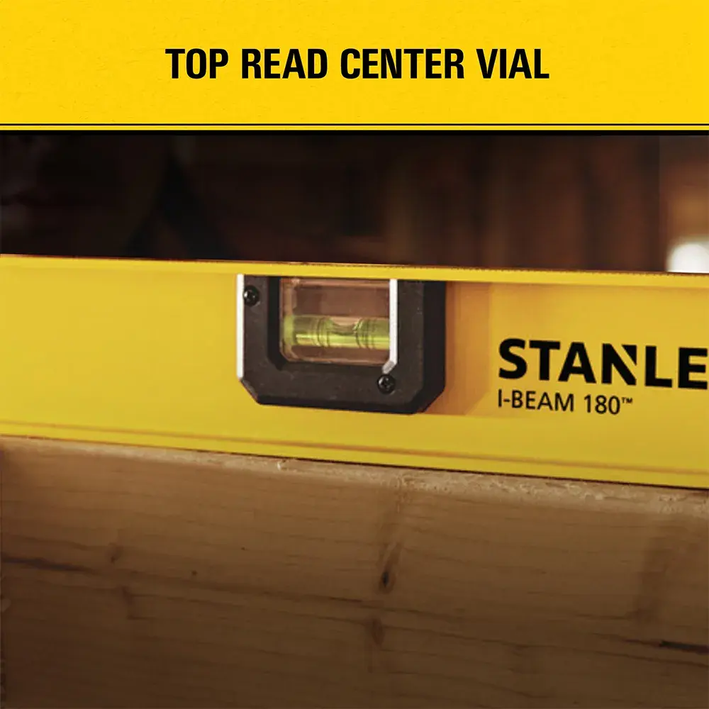 Close-up image of a yellow STANLEY I-Beam 180 level tool with a top read center vial, partially resting on a wooden surface.