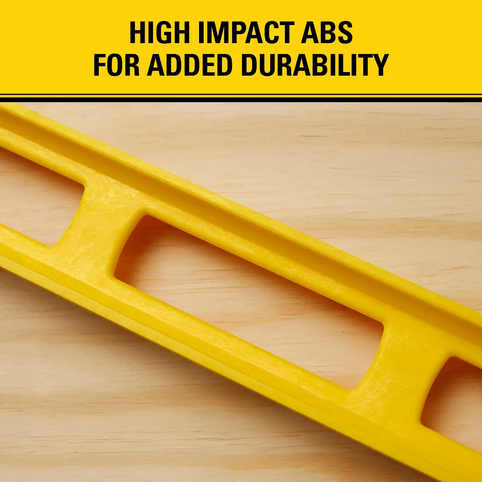 Close-up of a yellow Stanley level tool made of high-impact ABS plastic, placed on a wooden surface. The image highlights the product's added durability, with the text 'HIGH IMPACT ABS FOR ADDED DURABILITY' at the top.
