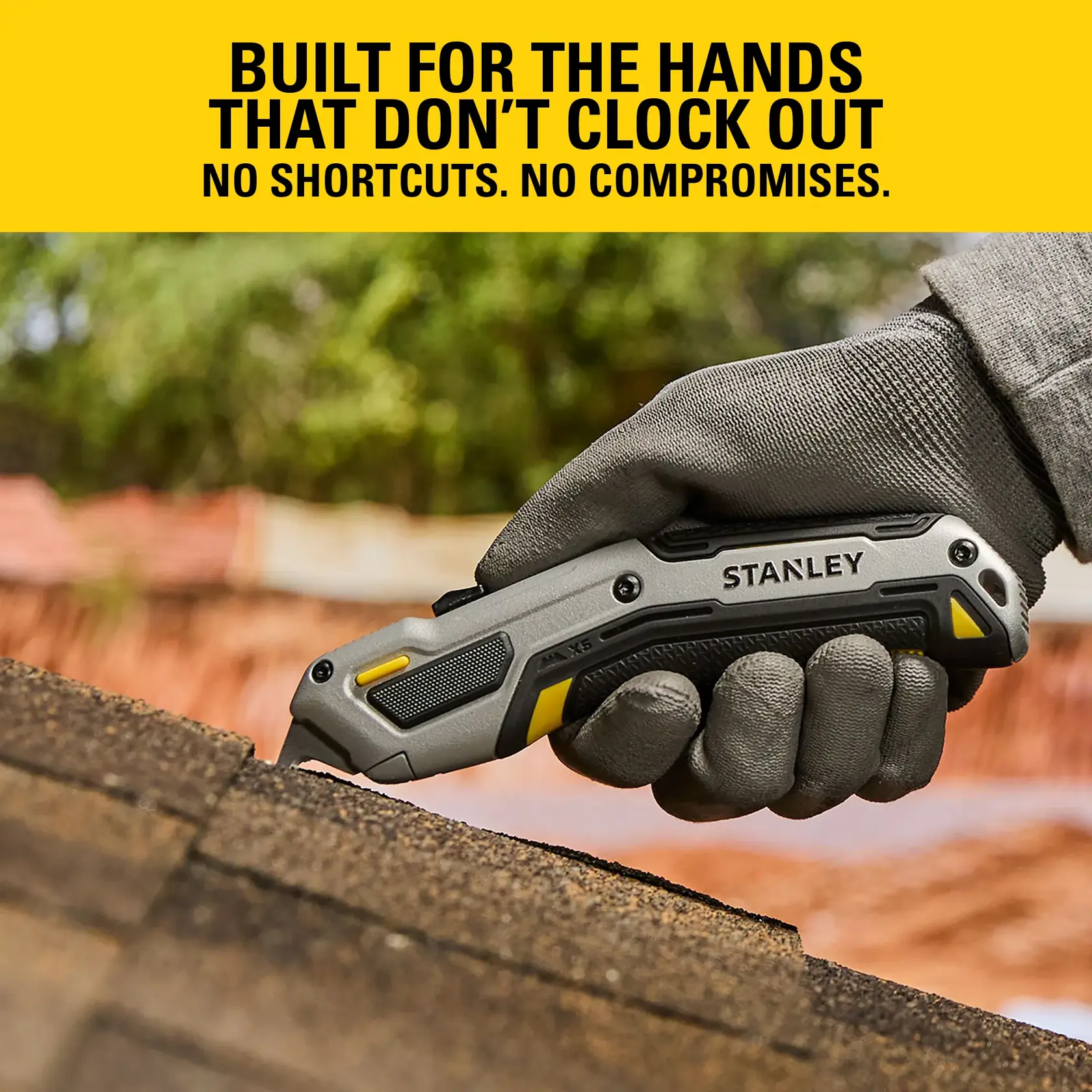 Stanley utility knife held by a gloved hand cutting roofing material outdoors. Bold yellow branding above.