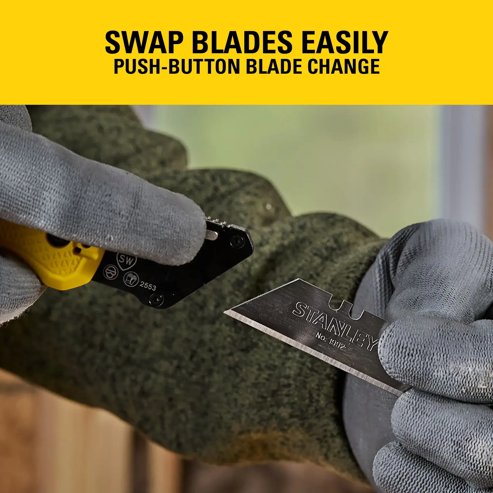 Gloved hands swap a STANLEY utility knife blade using a push-button for easy blade change.