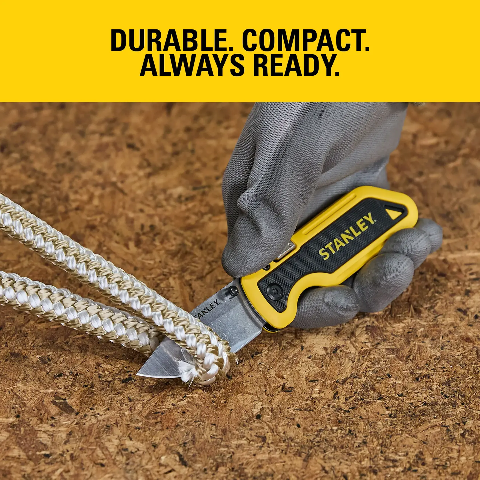 Stanley folding knife cuts thick rope on wood, held by gloved hand. Text: Durable. Compact. Always ready.