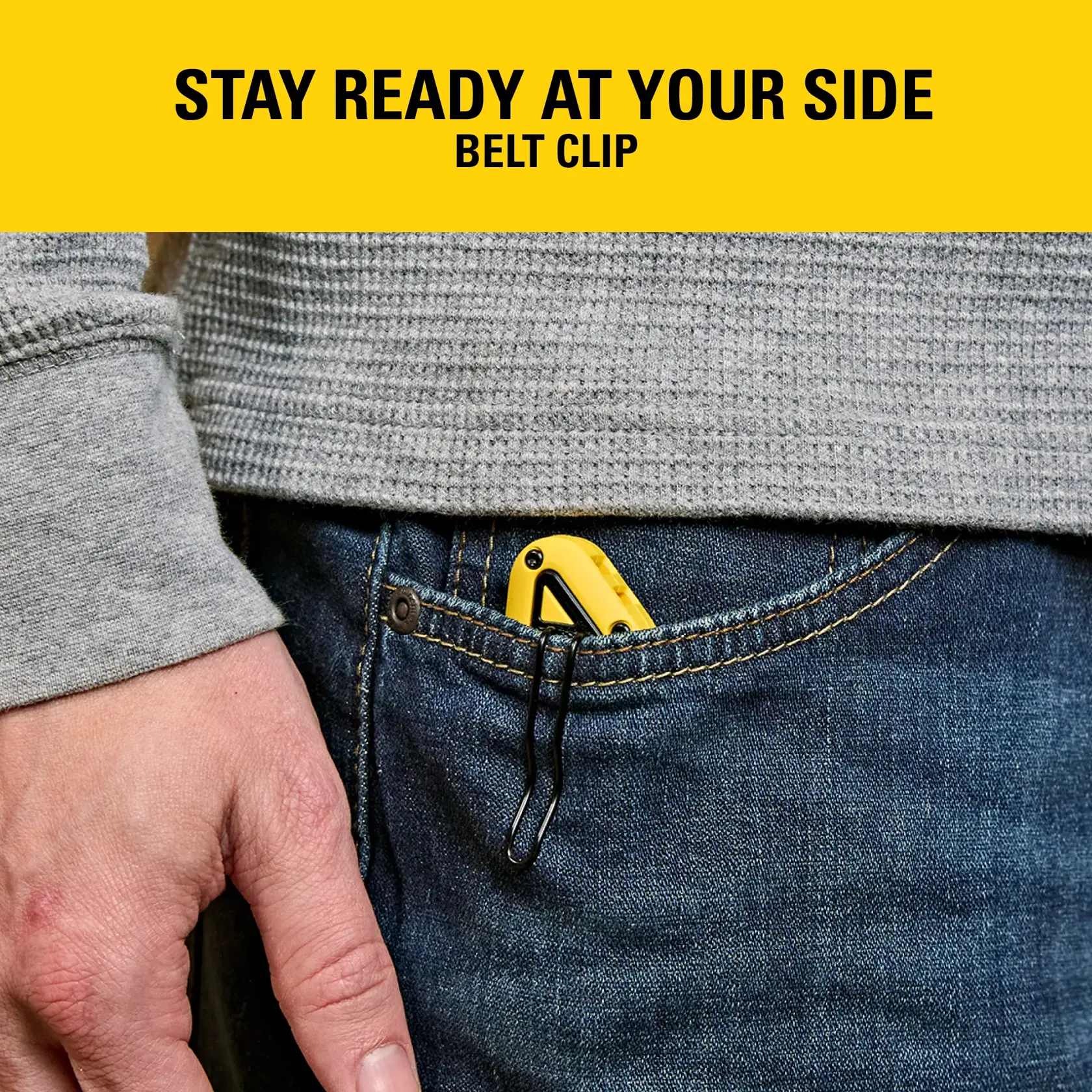 A yellow Stanley tool with belt clip is tucked into the front pocket of blue jeans, ready for easy access.