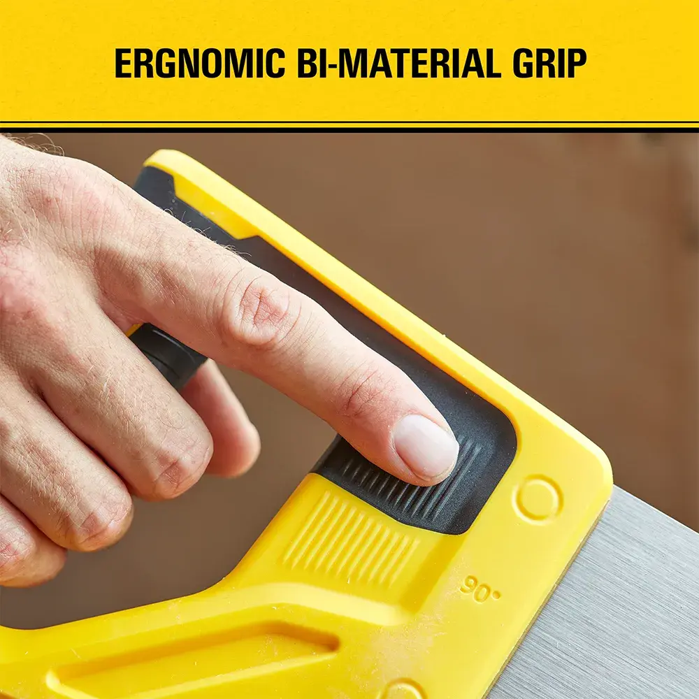 Close-up of a hand holding a yellow Stanley saw with an ergonomic bi-material grip, highlighted by the text above.