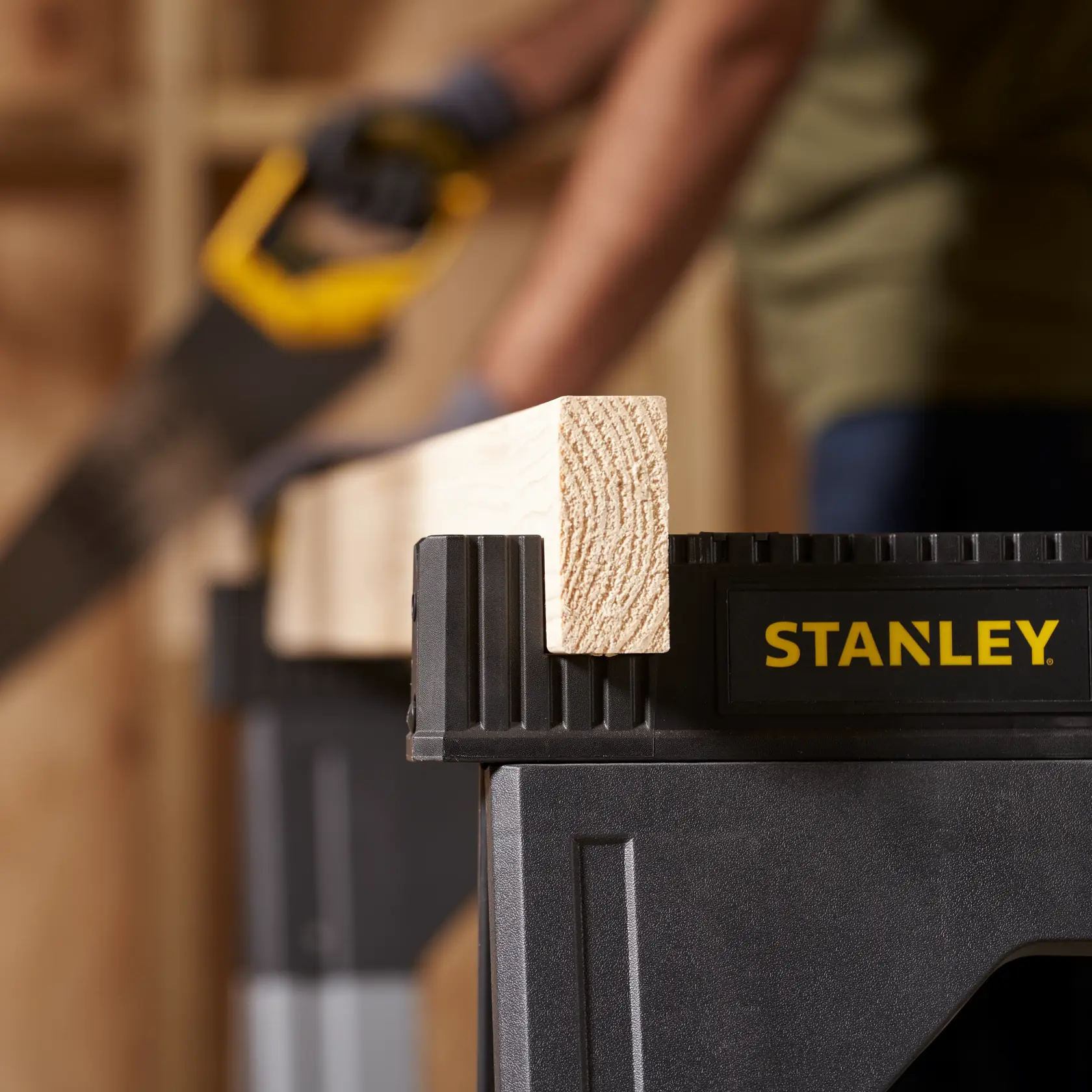 STANLEY SKU 011031S sawhorse holding wood plank, close-up in workshop setting.