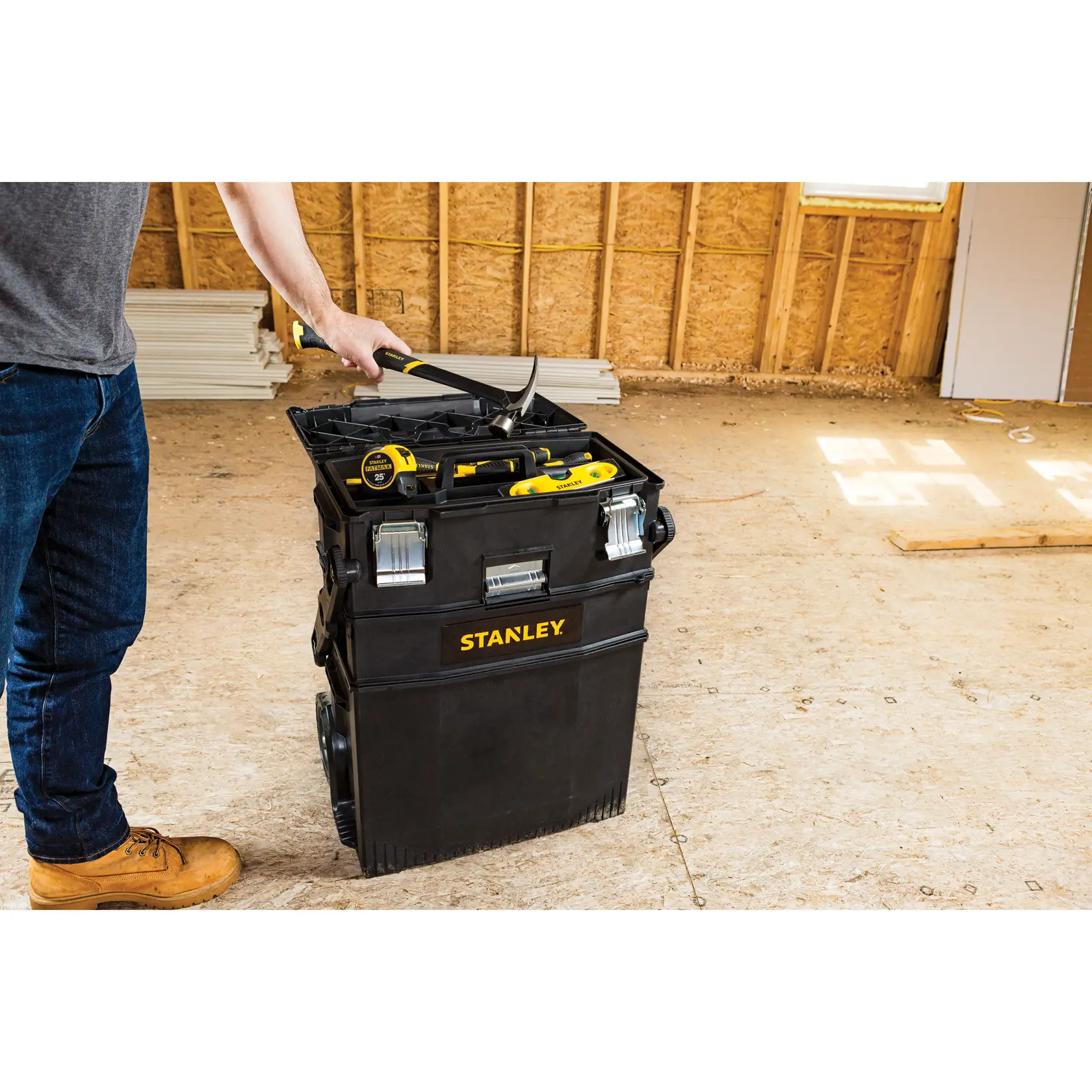 Stanley 020800R rolling tool chest in black with tools, indoor construction setting, side angle.