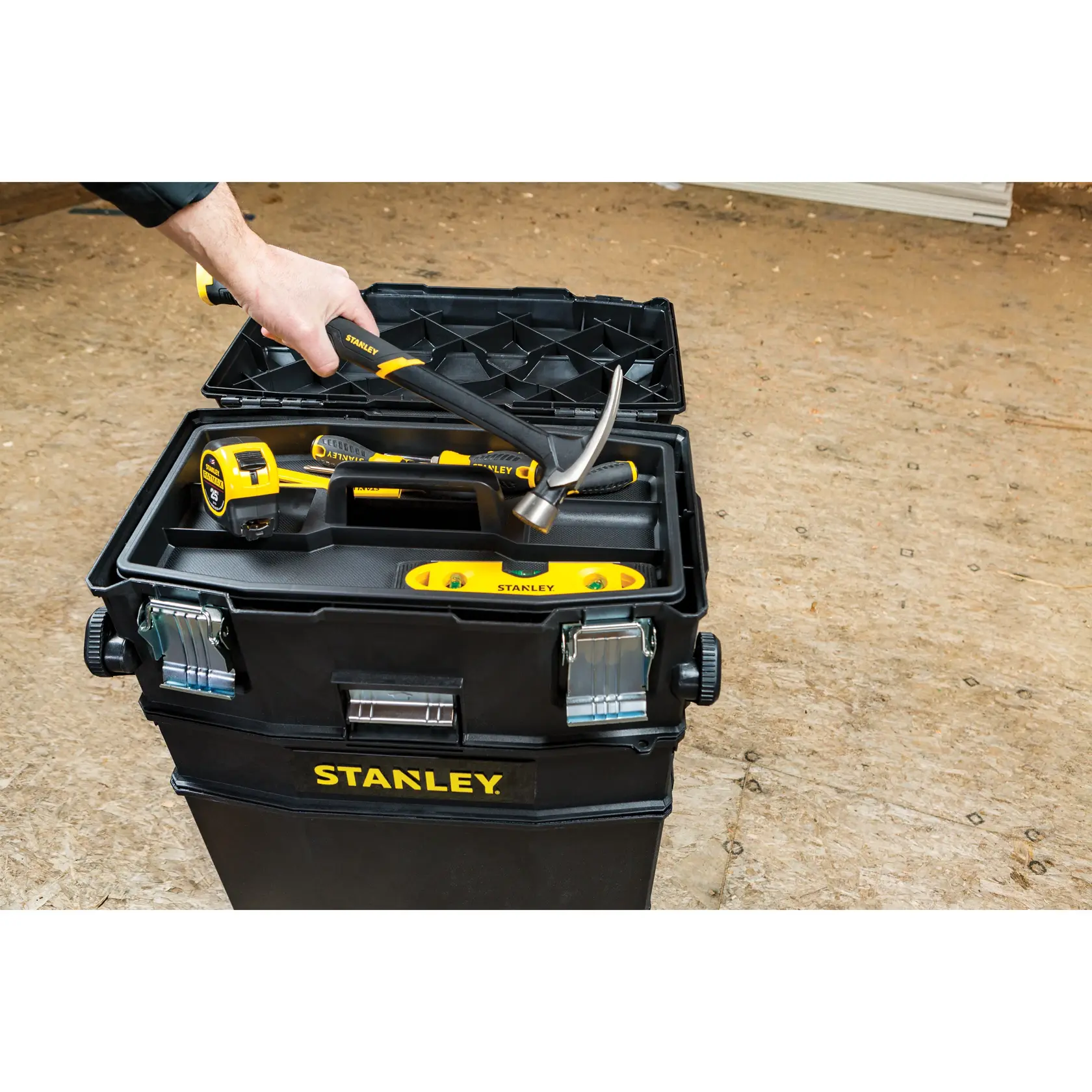 STANLEY 020800R toolbox photography with hand placing hammer inside, showing tape measure and level.