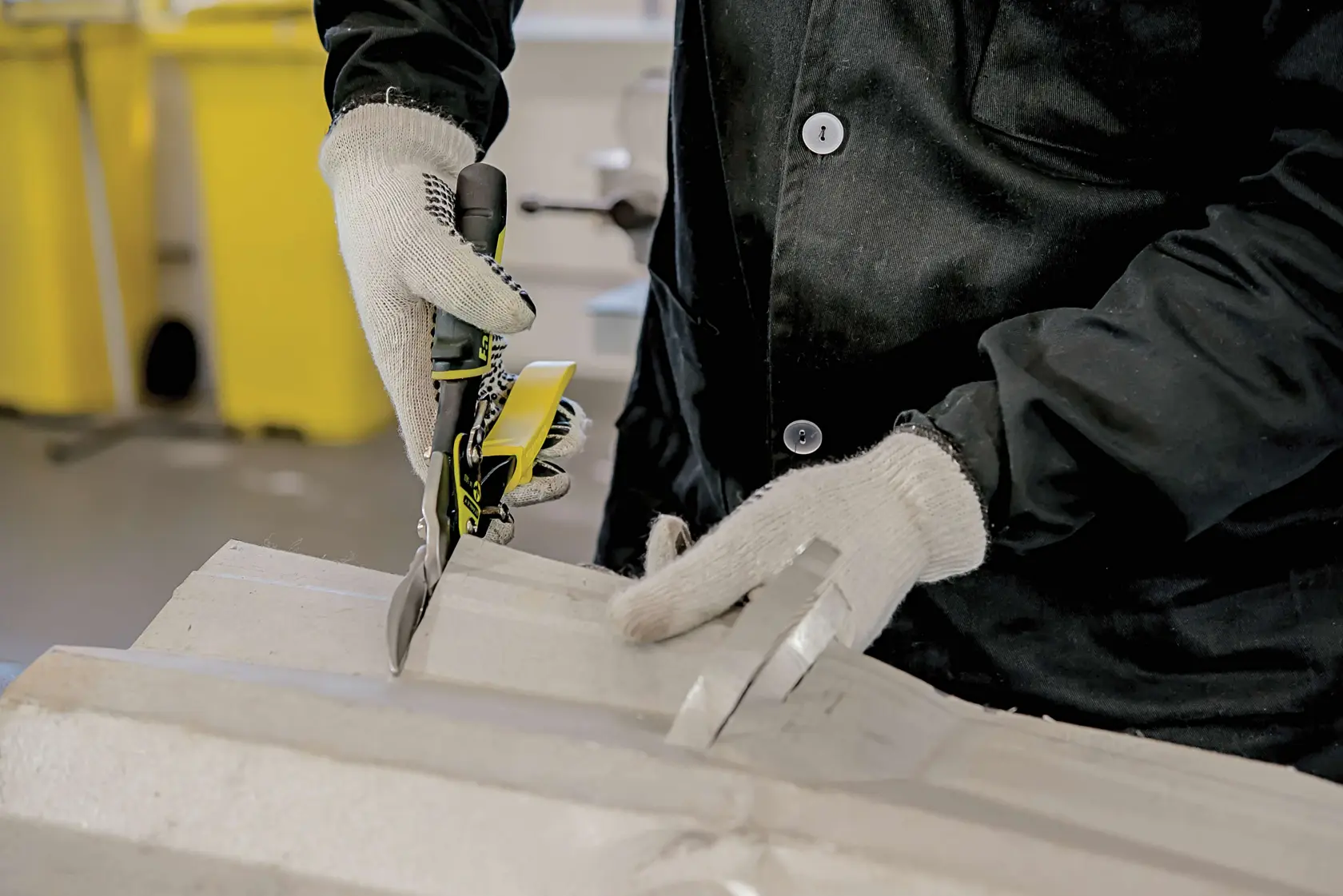 Photo of STANLEY 14-563 aviation snips cutting material, worn by gloved hands in workshop.
