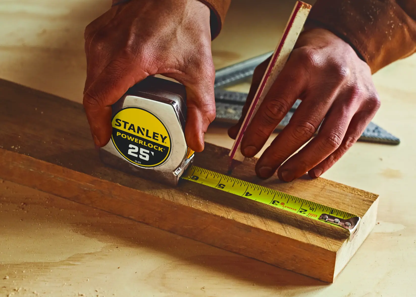 Stanley 33-425 PowerLock tape measure in use on wood, product photography.