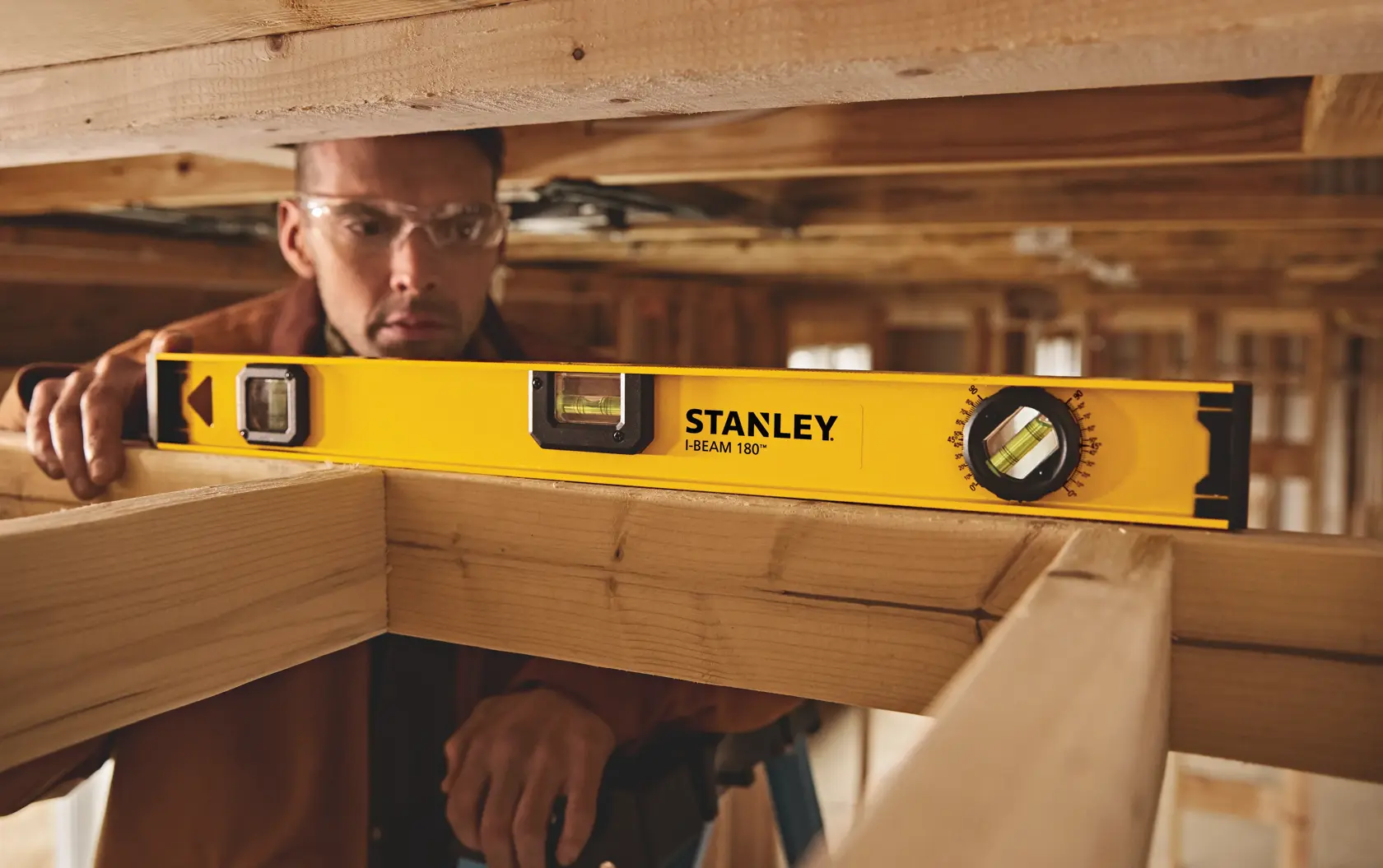 Photo of STANLEY 42-324 I-Beam 180° level tool used on wooden beams at a construction site.
