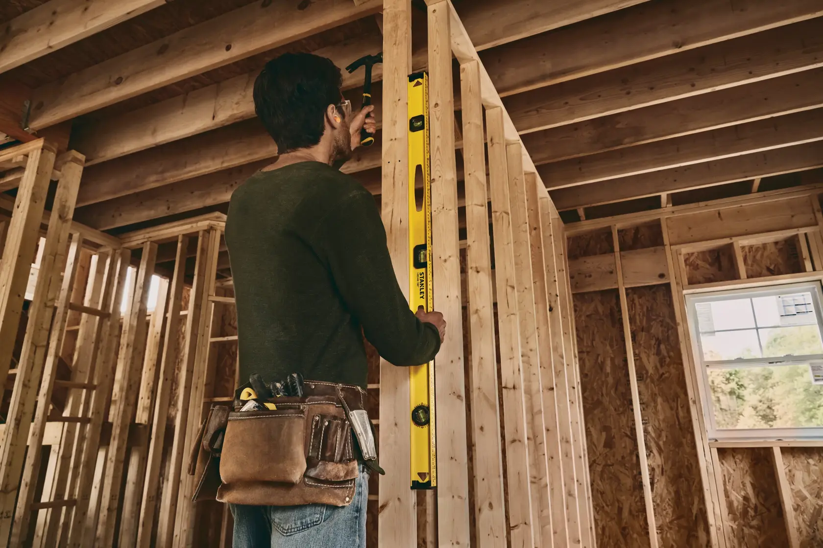 Photo of person using STANLEY 42-328 box beam level on wall frame at construction site.