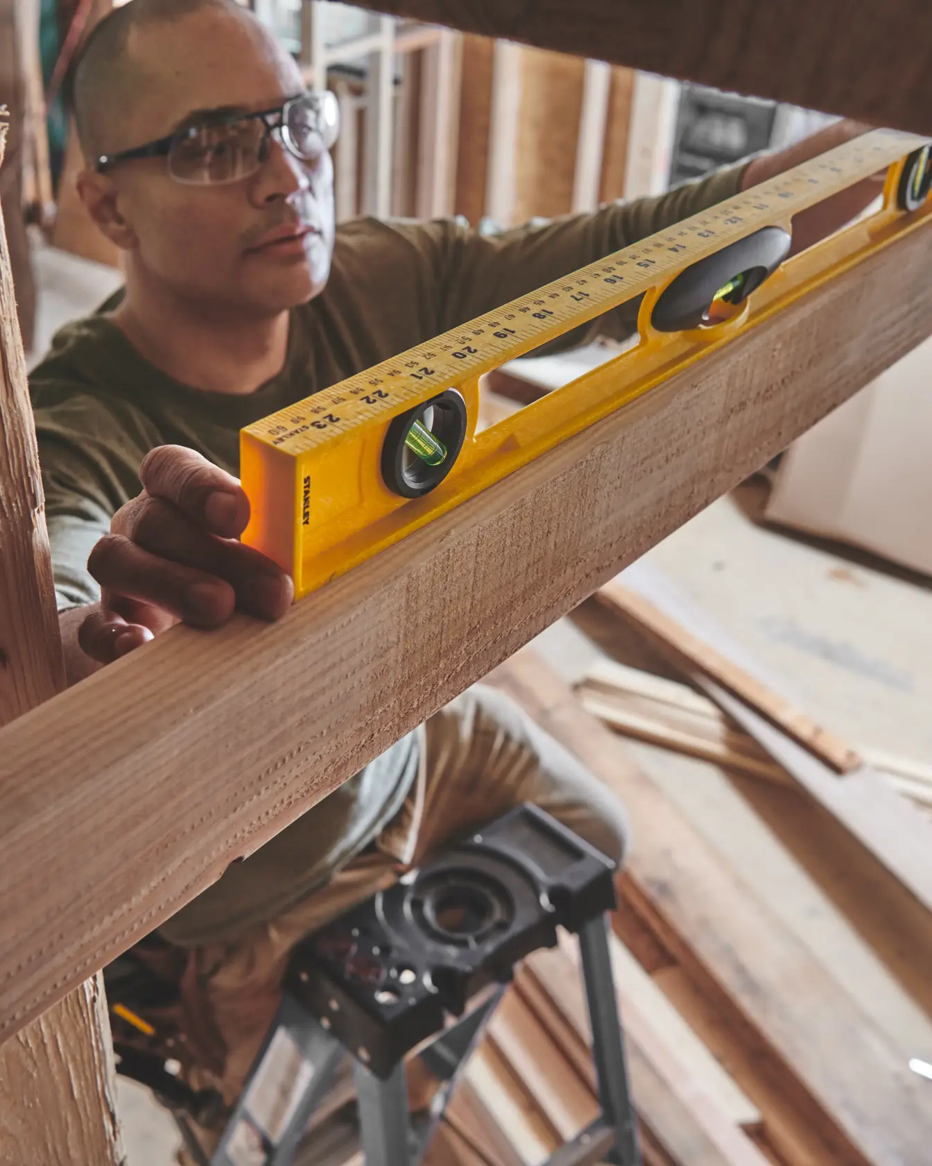 STANLEY 42-468 box beam level used to measure a wooden beam during construction, close-up action shot.