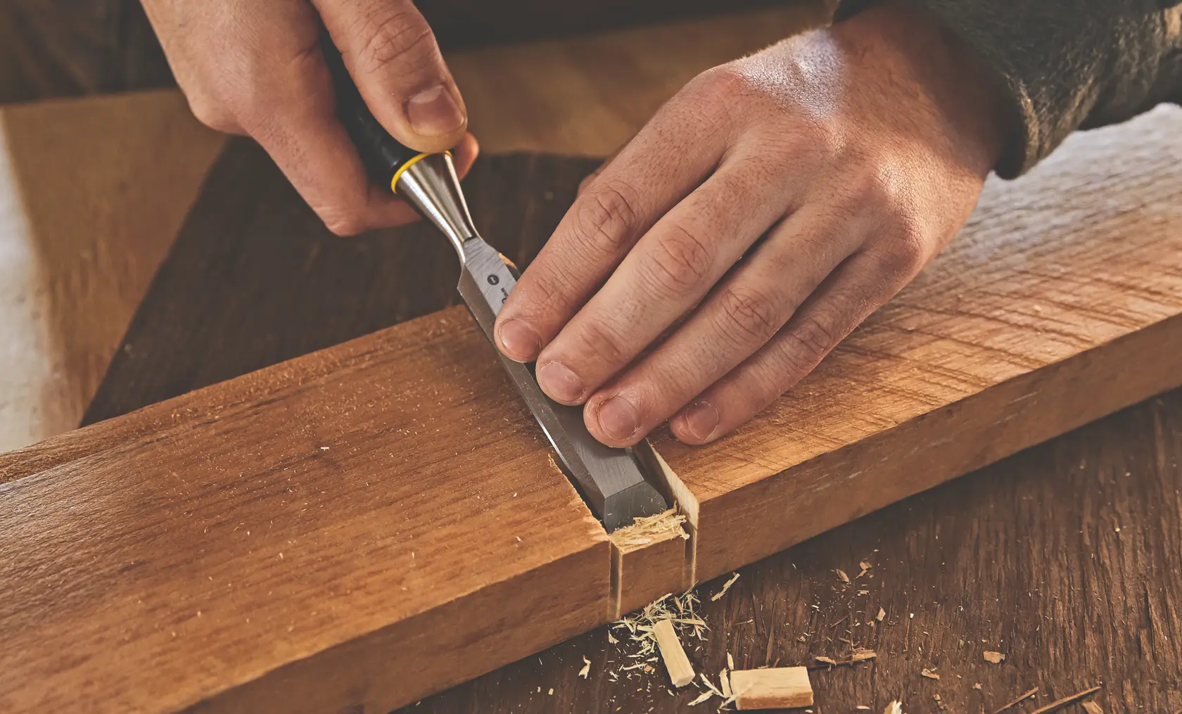 STANLEY STHT16727 chisel in use, hand woodworking on a wooden board, close-up photography.