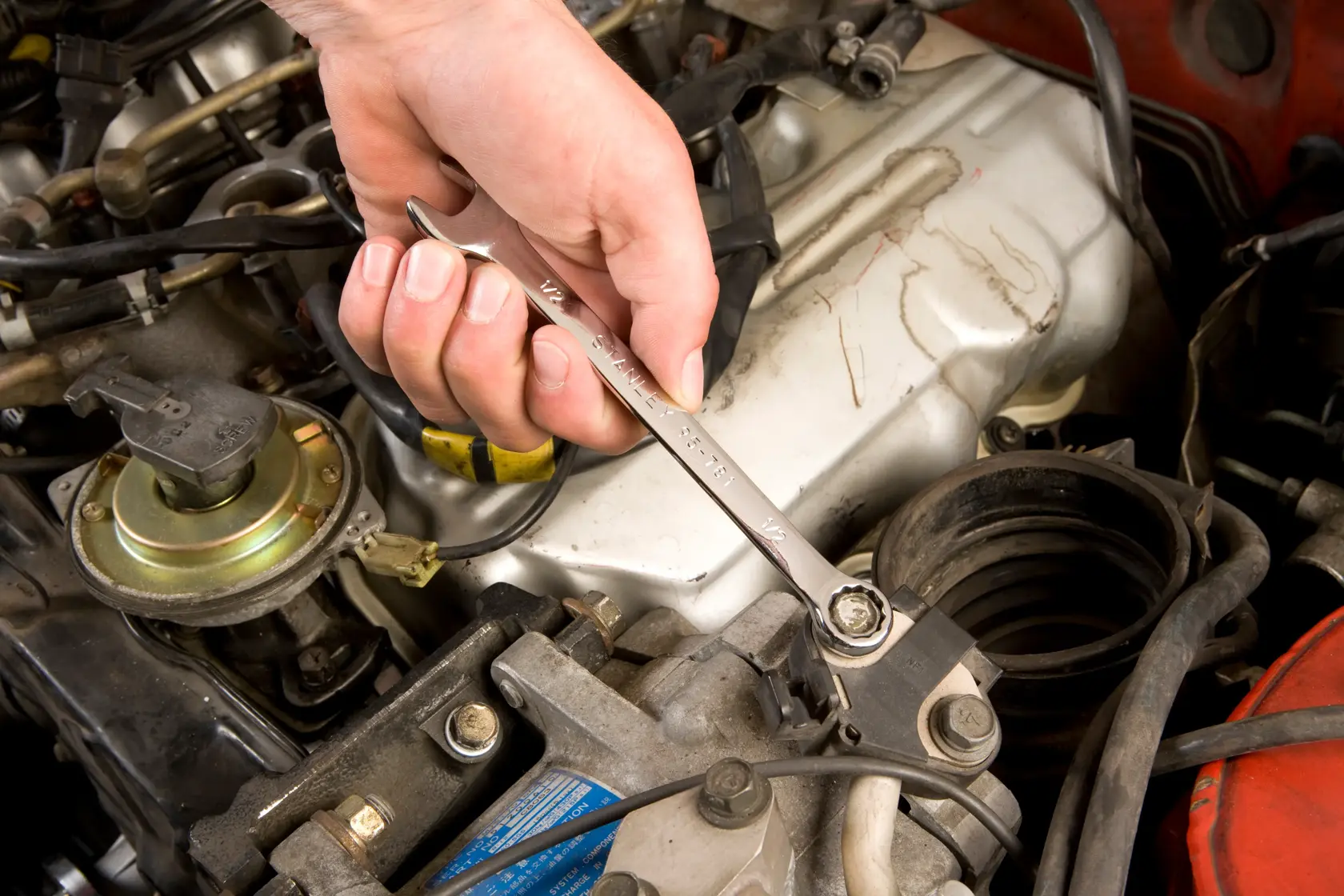 STANLEY STMT71654 wrench used on engine bolt, close-up photo of automotive tool in action.