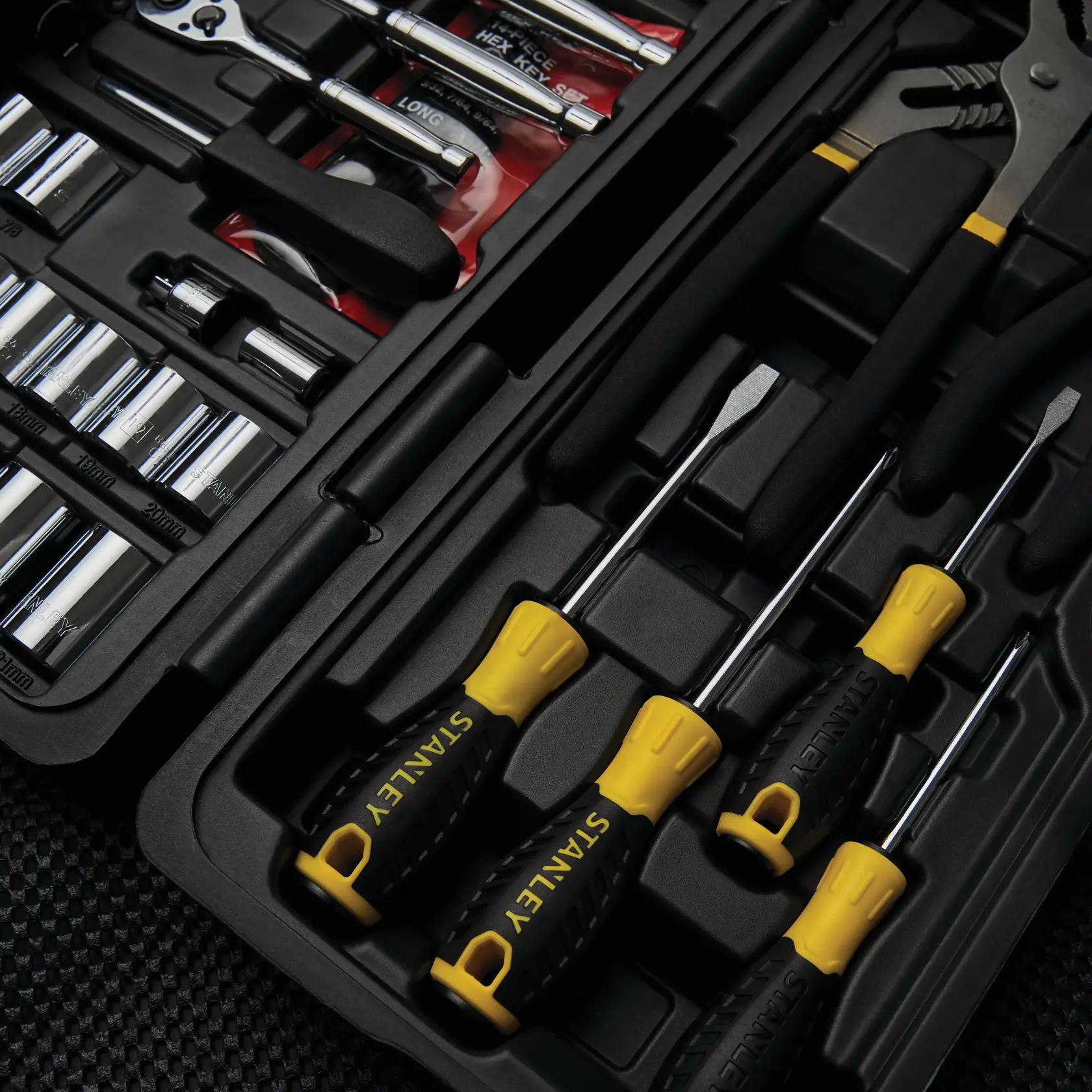 STANLEY STMT81031 tool kit with screwdrivers, pliers, sockets, and ratchet in black and yellow hard case.