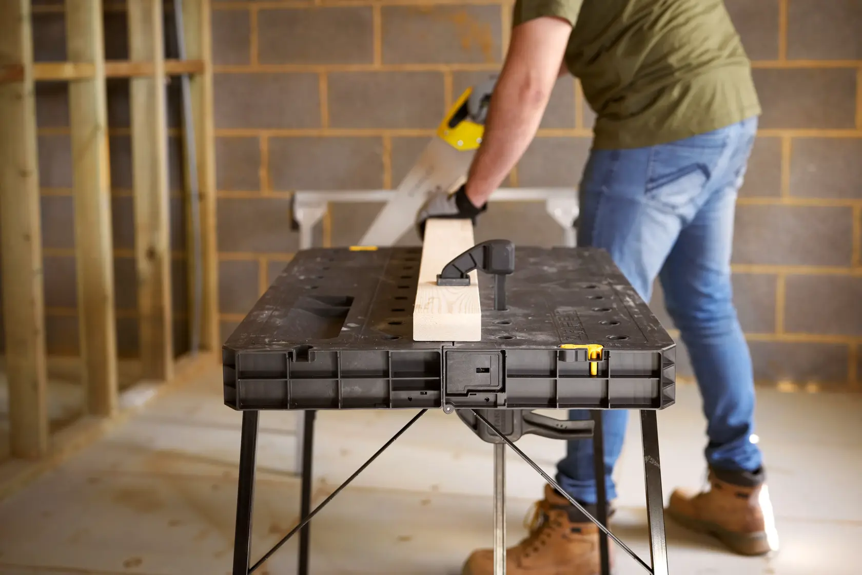 STANLEY STST11552 workbench with wood clamped, photo of product in use in construction setting.
