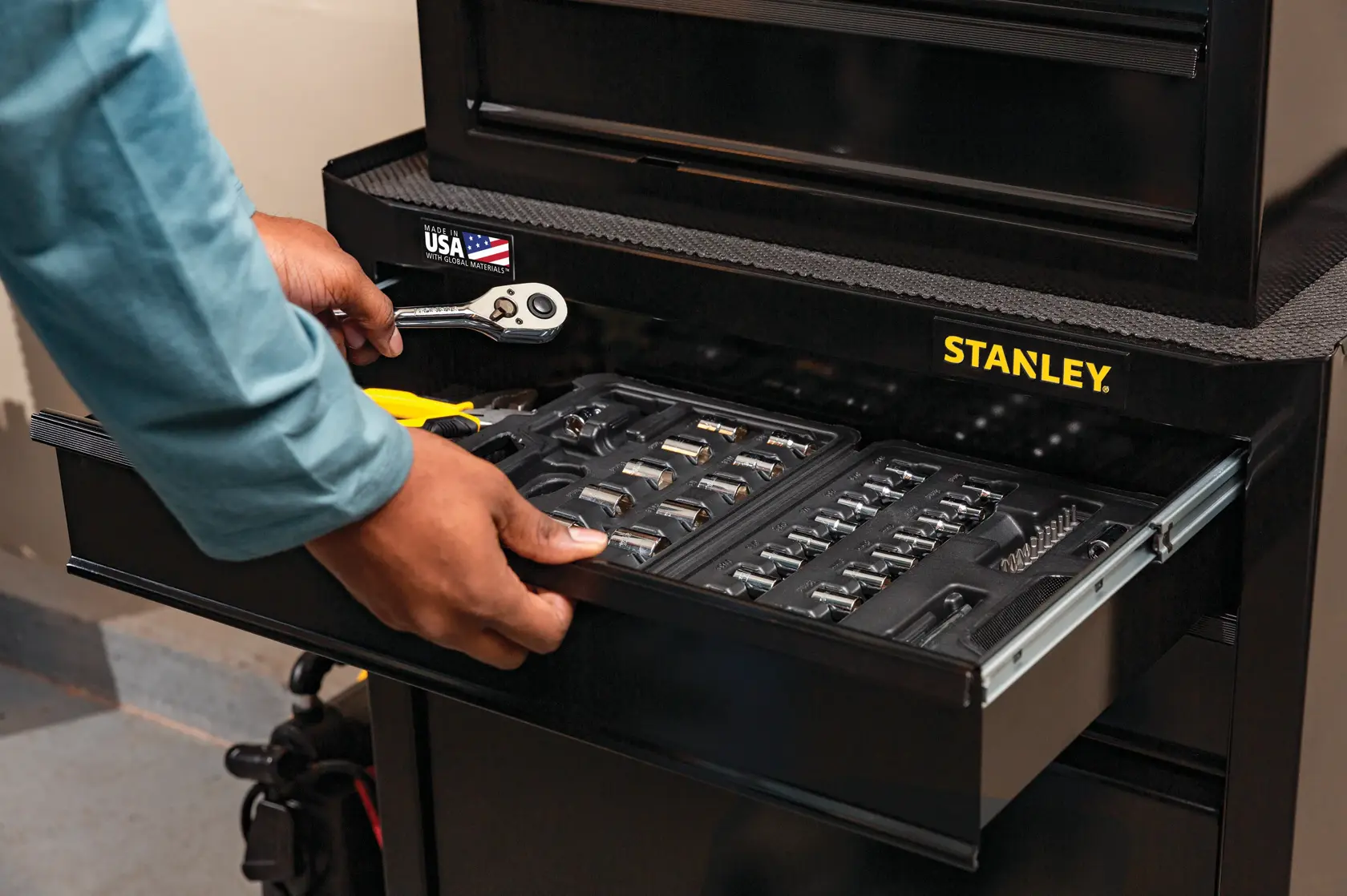 Photo of STANLEY STST22656BK tool chest drawer open, showing organized socket set, ratchet, and pliers inside.