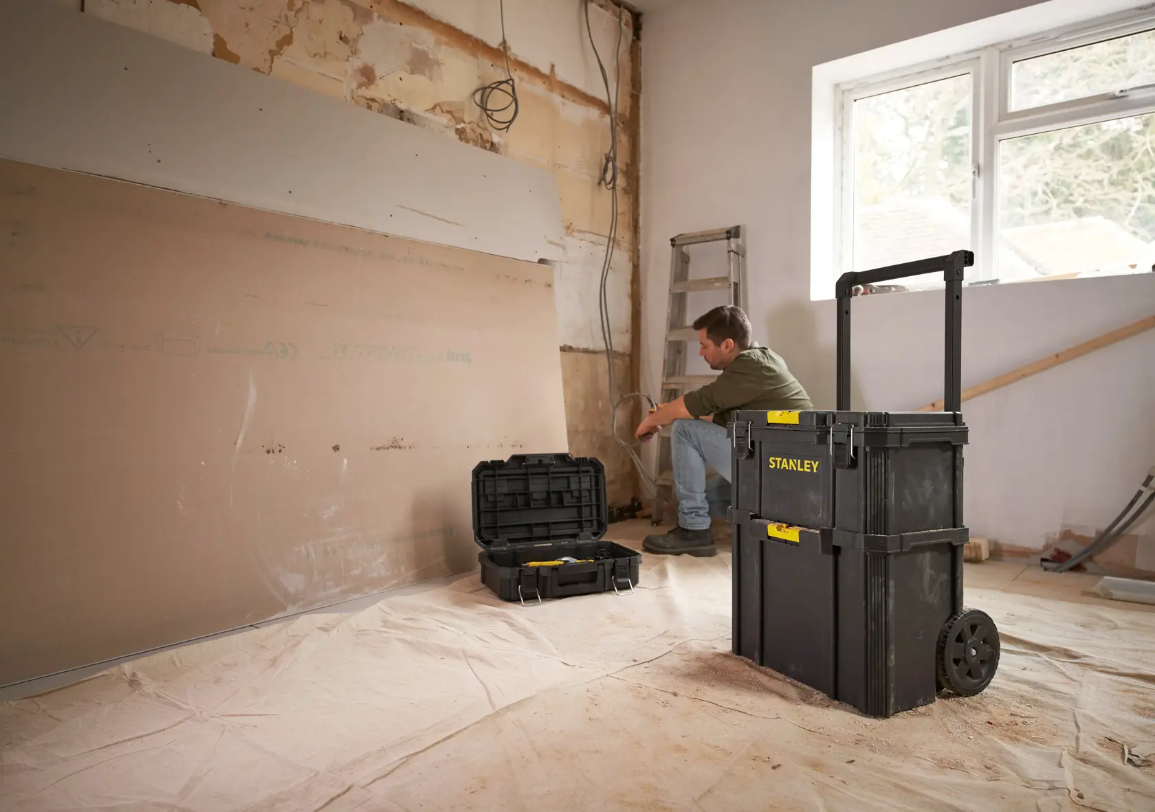 Photo of STANLEY STST60500 rolling tool box and open case on jobsite, black with yellow accents.