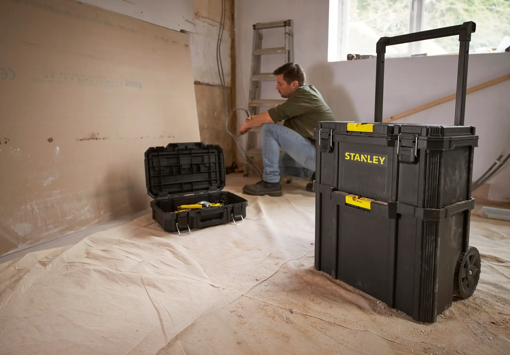 Photo of STANLEY STST60500 black rolling tool chest and open toolbox in a workshop setting.